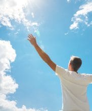 Man strive hands to the deep blue sky and sun. Religion and conceptual scene. Worship to God.